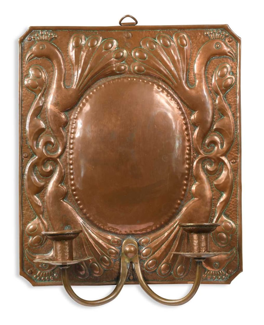 Attributed to John Pearson, an Arts & Crafts copper twin-branch wall sconce, embossed with peacock: Attributed to John Pearson, an Arts & Crafts copper twin-branch wall sconce, embossed with peacock motifs around the central black cartouche 37 x 30cm
