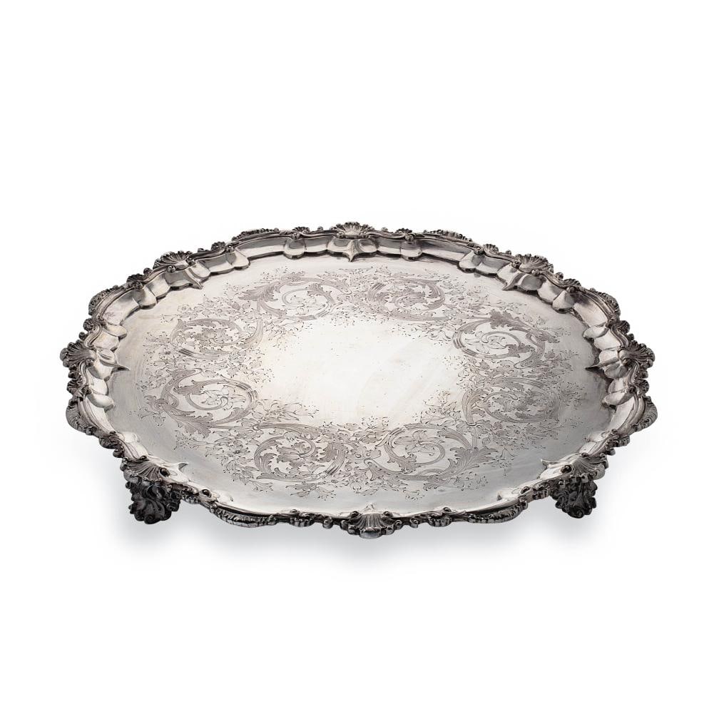 A Victorian silver salver, mark of John Hunt & Robert Roskell, London 1873, 'Chippendale' style with: A Victorian silver salver, mark of John Hunt & Robert Roskell, London 1873, 'Chippendale' style with shell and scroll rim, the field engraved with decorative foliage, raised on four pierced scrolling