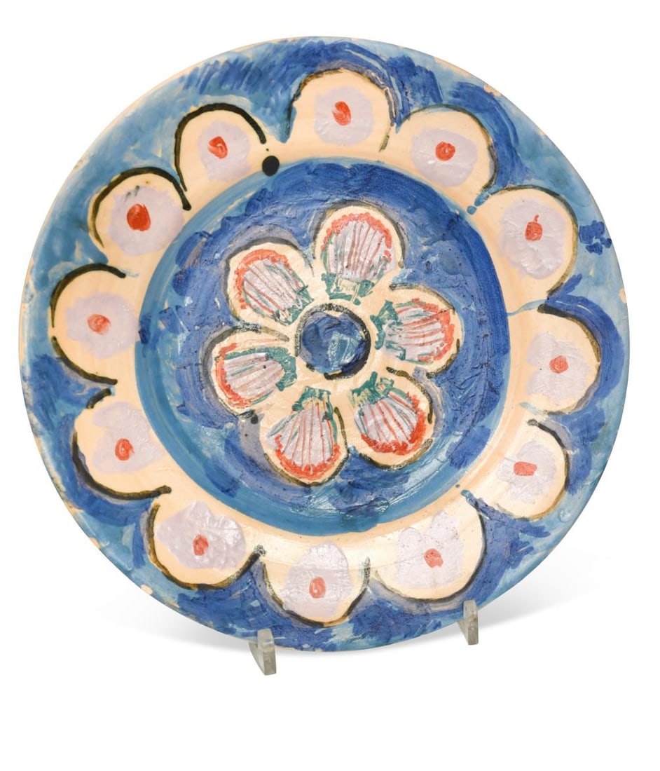 § Quentin Bell (1910-1996), a painted pottery plate,: § Quentin Bell (1910-1996), a painted pottery plate, hand-painted with a central floral design and with radiating petals to the border, painted signature to underside 27.5cm diameter