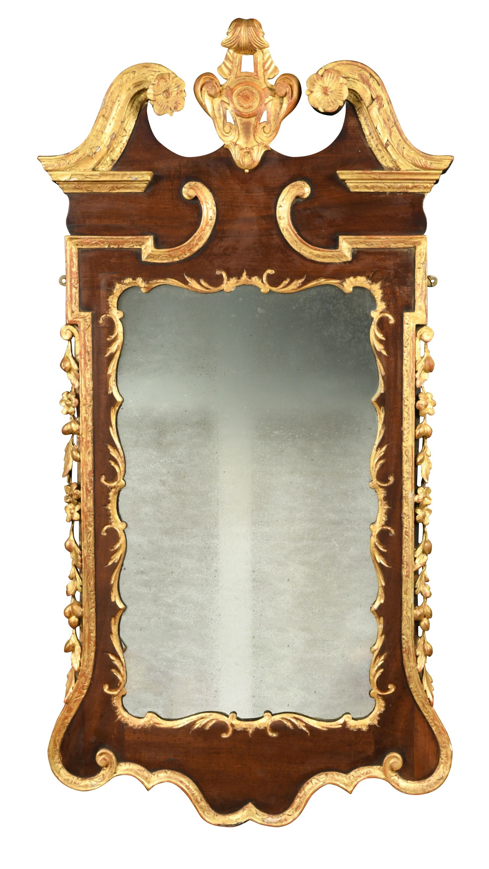 A George II style mahogany and parcel gilt wall mirror,: A George II style mahogany and parcel gilt wall mirror, in the manner of William Kent, the broken swan neck pediment over a shaped mirror plate flanked by fruit and foliate carved decoration 136 x 70c