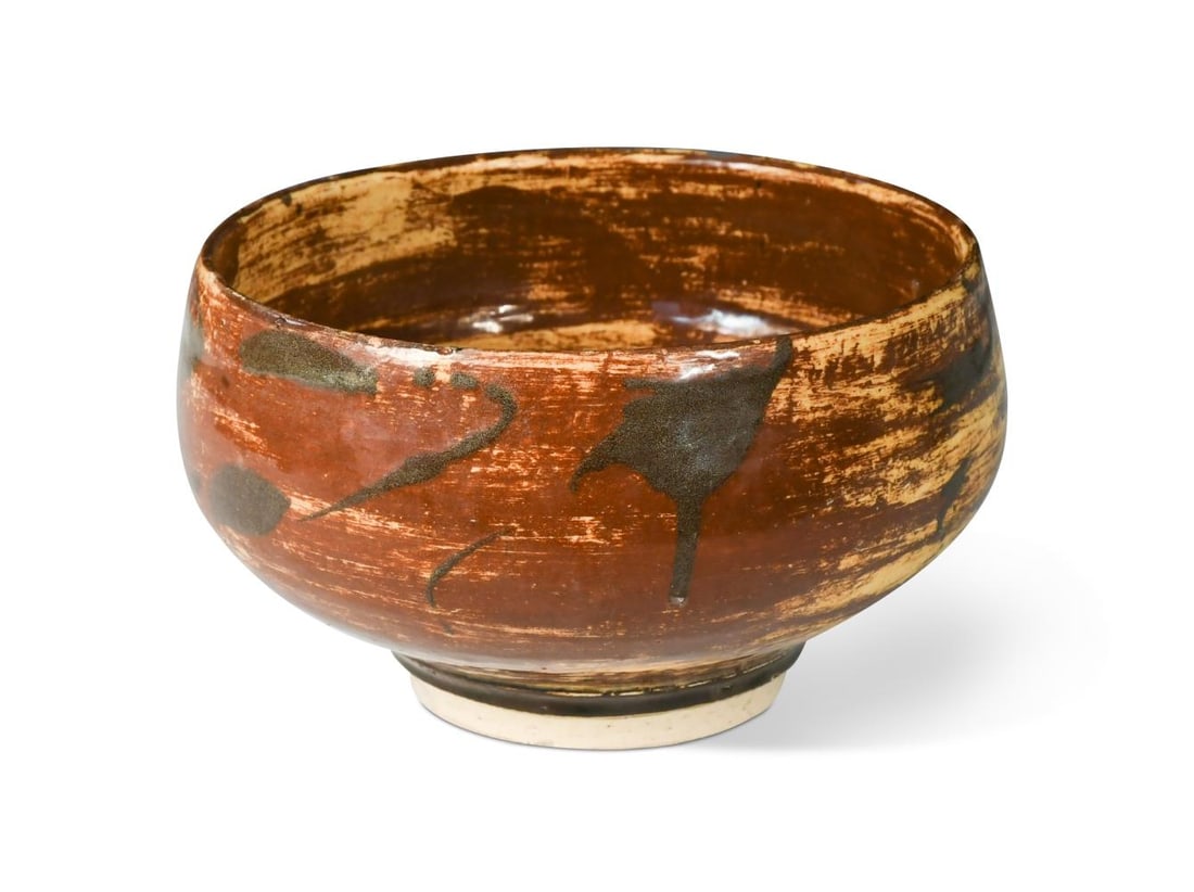 § Bernard Leach (1887-1979), an earthenware footed bowl, circa 1920s,: § Bernard Leach (1887-1979), an earthenware footed bowl, circa 1920s, the body slip decorated with tenmoku and persimmon over an oatmeal ground, impressed St Ives and potter seal marks to underside 1