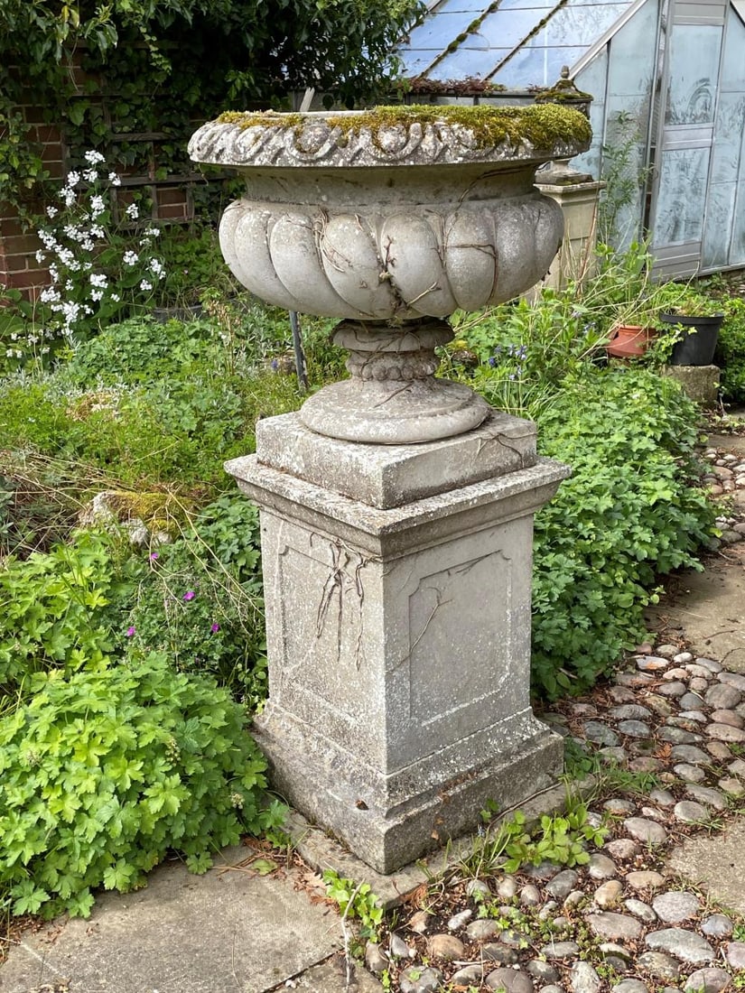 A reconstituted stone garden planter, late 20th century,: A reconstituted stone garden planter, late 20th century, of gadrooned body on a square plinth base 70cm diameter, 133cm high