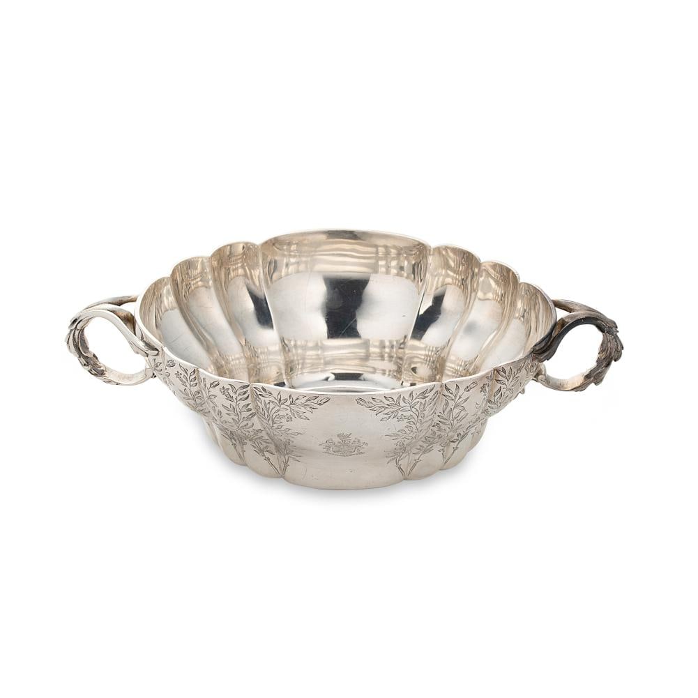 A Victorian silver two handled bowl,: A Victorian silver two handled bowl, mark of Charles Thomas Fox & George Fox, London 1854, of oval form, the scalloped side with bright cut foliate engraving around two abstract cartouches, one creste