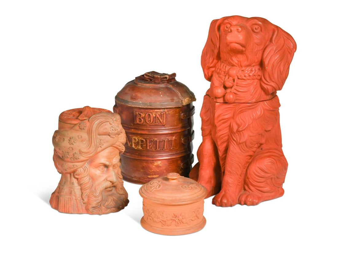 A group of four redware items,: A group of four redware items, to include a large vessel modelled as a spaniel, two lidded boxes and a tobacco box modelled as a North African man