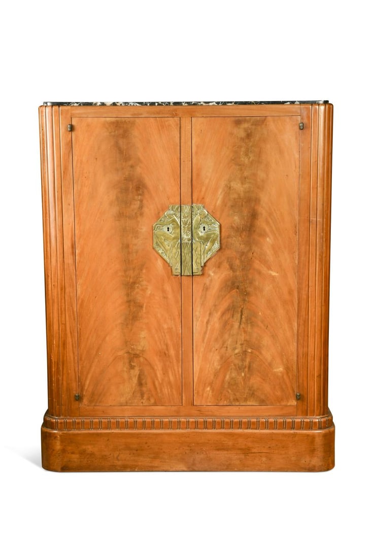 An Art Deco fruitwood veneered cabinet, circa 1925, designed by Clément Goyeneche (1893-1984),: An Art Deco fruitwood veneered cabinet, circa 1925, designed by Clément Goyeneche (1893-1984), inset with black and white marble top above a pair of cupboard doors with octagonal cast brass escutcheo