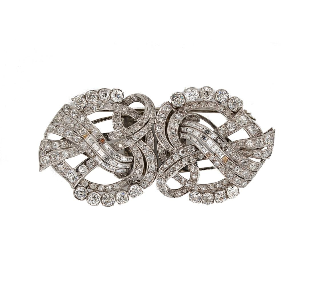 A diamond set double clip brooch,: A diamond set double clip brooch, pierced ribbon design, set with old mine, old European, Swiss, rose and baguette cut diamonds, estimated approximate total diamond weight 10.70ct, dimensions 8 x 4cm,