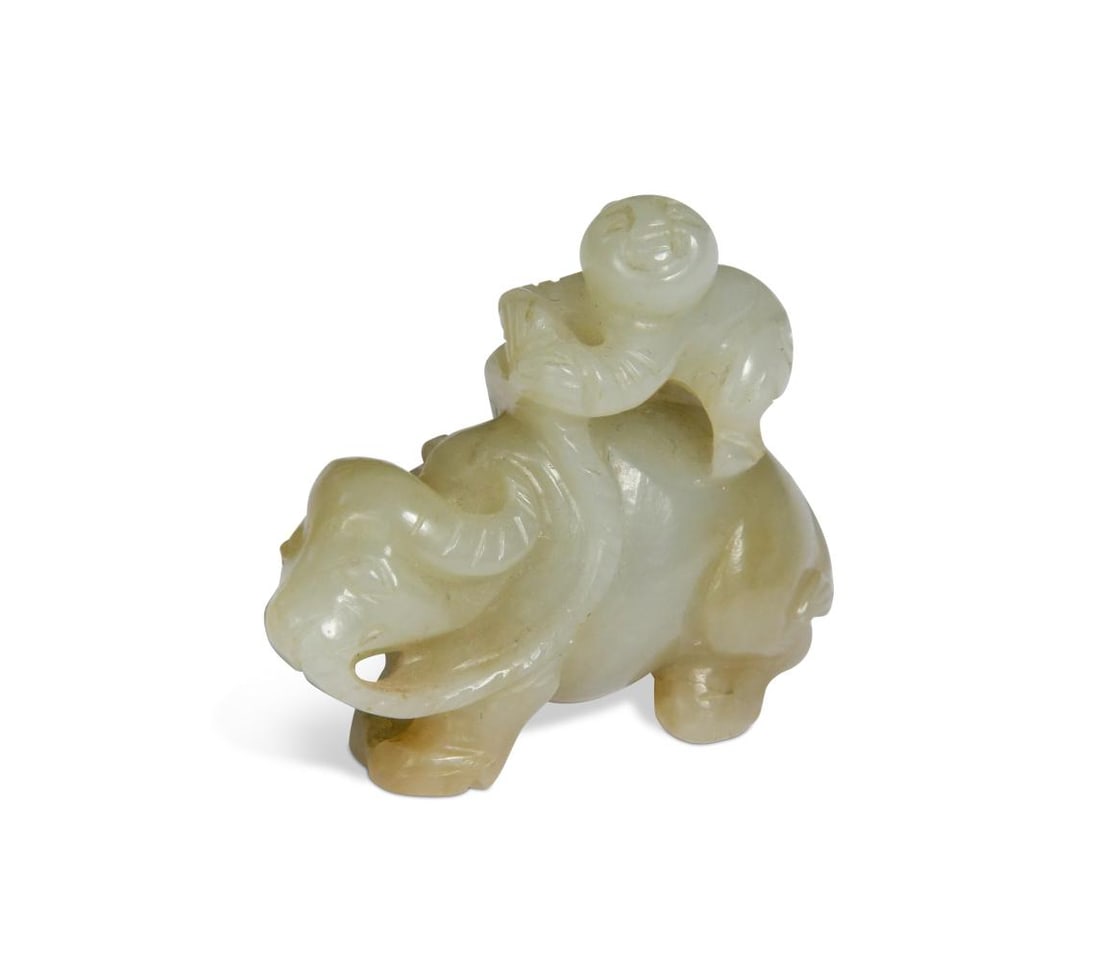 A Chinese mutton fat jade small carving of a boy and water buffalo, late Qing Dynasty,: A Chinese mutton fat jade small carving of a boy and water buffalo, late Qing Dynasty, the semi-recumbent beast tethered back by a rope held by the half-standing boy 4.1 x 4.6cm small losses (natural?