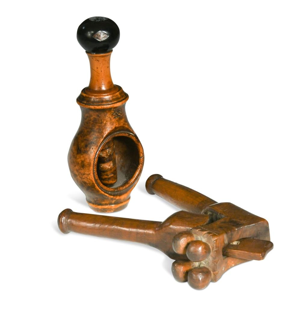 A pearwood nutcracker, early 18th century: A pearwood nutcracker, early 18th century of four ball crossover form decorated with incised hatching and a flower pot 13cm together with a burr wood screw-action nutcracker, having a decorative finia