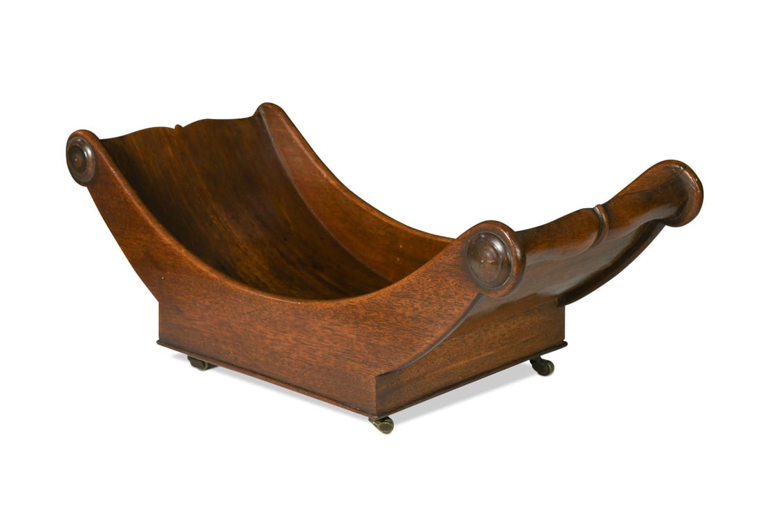 A George III mahogany cheese coaster,: A George III mahogany cheese coaster, of typical boat-shaped form, raised on brass barrel castors 17 x 43 x 21cm