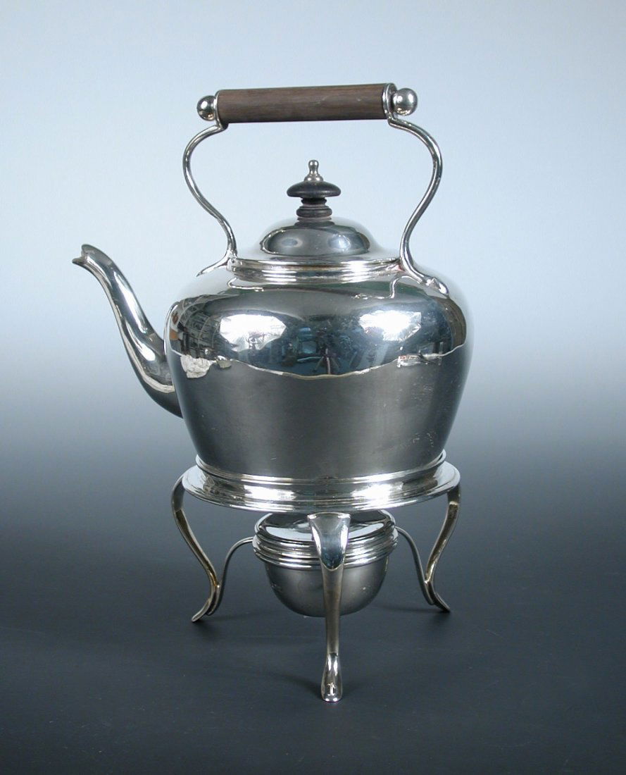 A late Victorian silver teakettle: A late Victorian silver teakettle by Charles Stuart Harris, London 1899 of plain tapering rounded shape, the handle with wooden insulator, together with a matching Edwardian heater stand with central