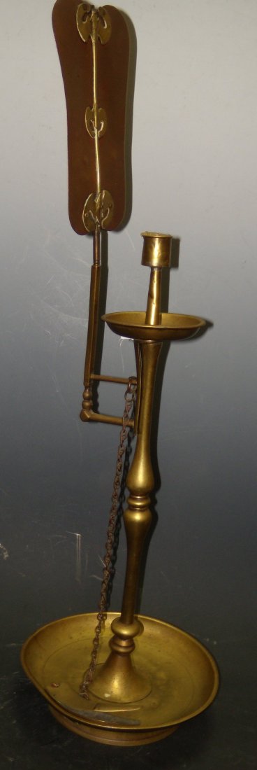 A 19th century brass candlestick ,: A 19th century brass candlestick , now with a candleholder removable from the pricket beneath, the copper fan shaped reflector supported by a brass rib and three bats, the column on a dished base, pin