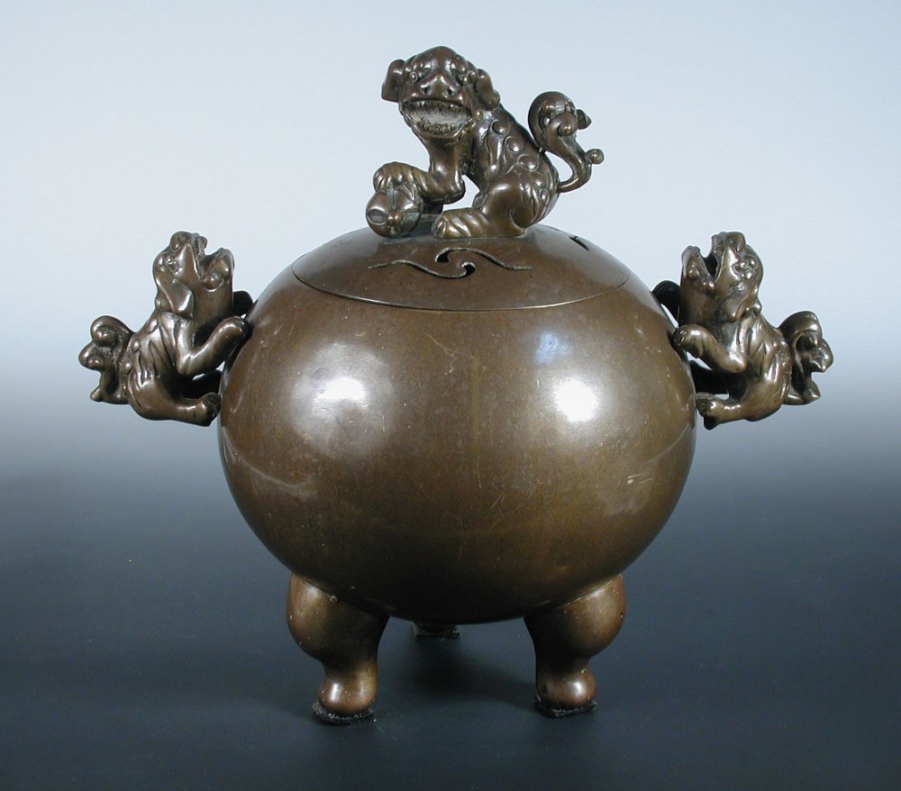 A 19th century bronze censer and cover,: A 19th century bronze censer and cover, the compressed spherical body on three chubby legs, Buddhist lions forming the handles and finial to the pierced cover, 39cm (15.25 in.) high (2)