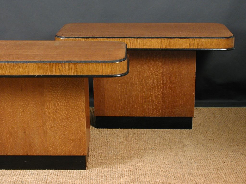 A pair of Art Deco oak console tables,: A pair of Art Deco oak console tables, the rounded rectangular tops with ebonised detailing supported on cuboid section bases with ebonised plinths (2) 73 x 125 x 58cm (28 x 49 x 23in)