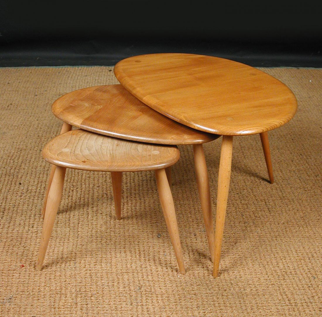 A nest of three blond elm Ercol 'Pebble' occasional tab: A nest of three blond elm Ercol 'Pebble' occasional tables, the largest 40cm x 65cm x 44cm