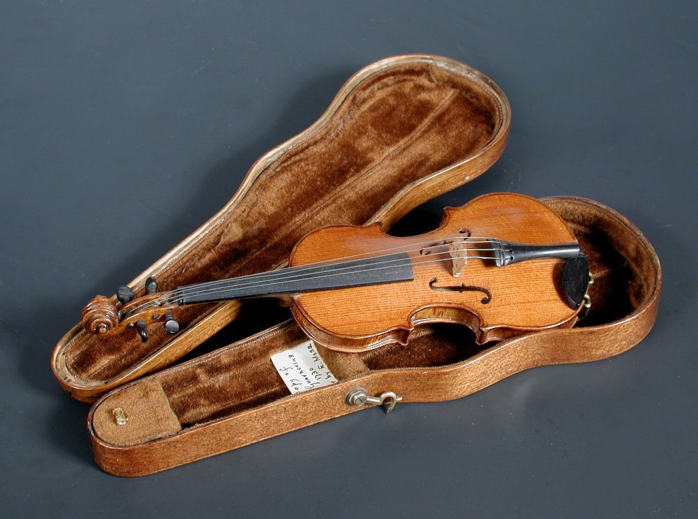 A miniature violin by Edwin Moss, dated 1937: A miniature violin by Edwin Moss, dated 1937 after a model by Guarnerius, with paper label, length 158mm, with wooden silhouette case