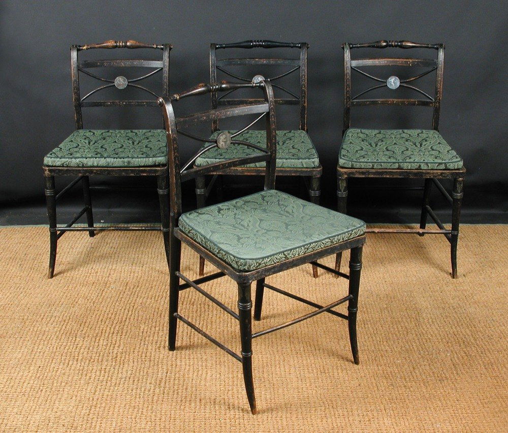 A set of four painted Regency dining chairs, circa: A set of four painted Regency dining chairs, circa 1810, turned bar backs and 'Amorini' decorated tablet splats, cane seats on slender turned legs - three with later stretchers (4) 82 x 45cm (32 x 18i