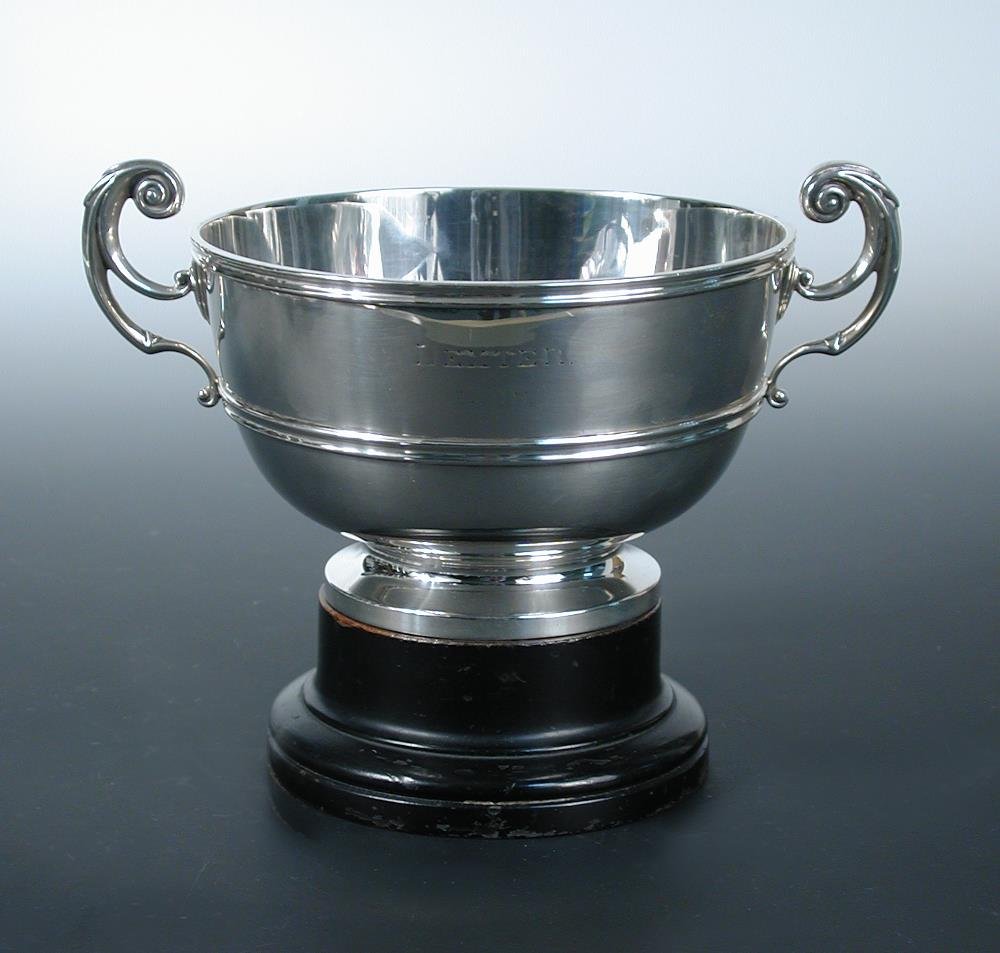 A small Edwardian silver rosebowl,: A small Edwardian silver rosebowl, by Charles Stuart Harris, London 1903, of plain circular form with moulded girdle and edge and with two leaf capped flying scroll handles, raised on a low pedestal f