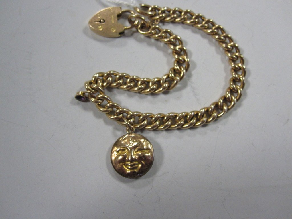 A Victorian curb link bracelet with locket clasp both: A Victorian curb link bracelet with locket clasp both stamped '15ct', the uniform solid links suspending a circular theatrical mask charm with comic and tragic faces, and a small amethyst, length 20cm