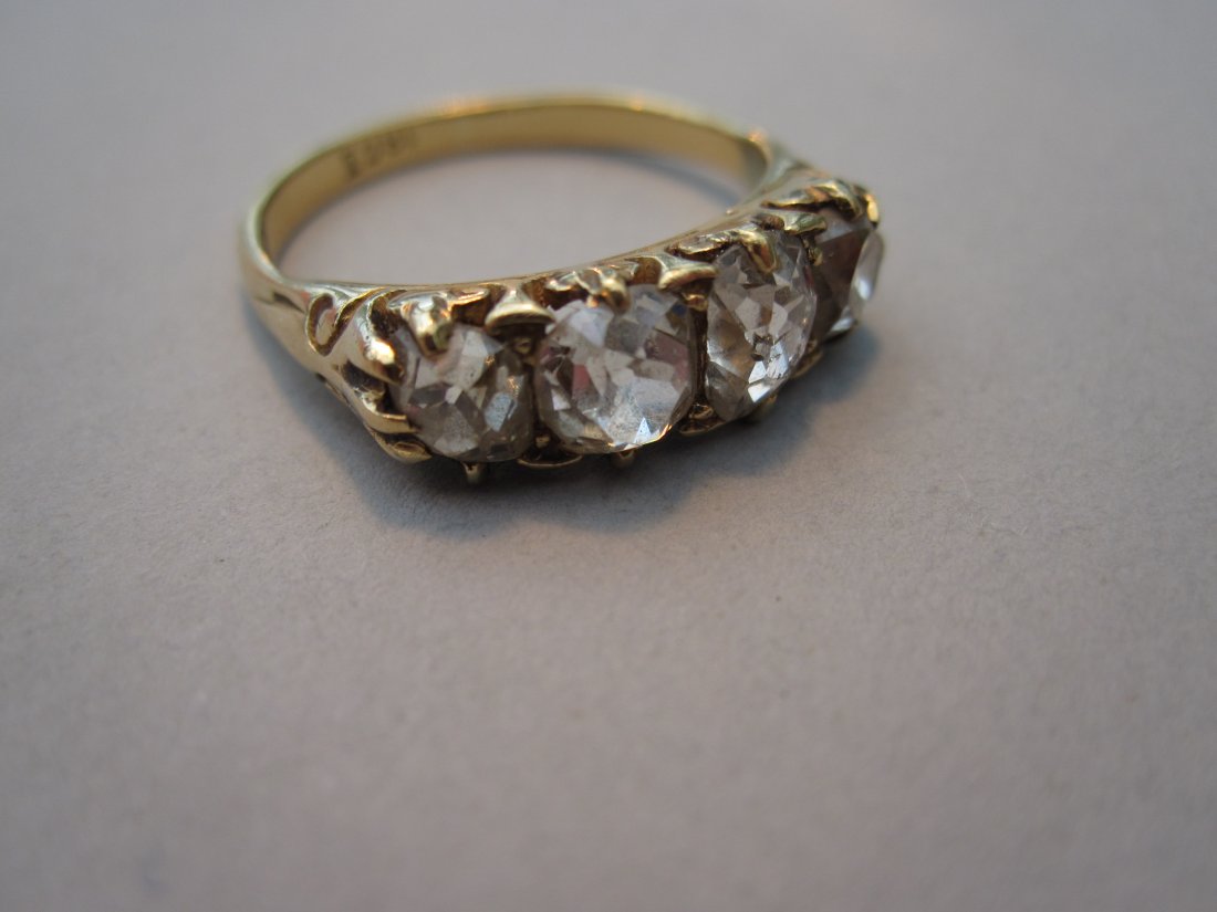 An old cut diamond four stone ring,: An old cut diamond four stone ring, claw set with graduated old cushion cut diamonds to carved shoulders and a plain tapered shank stamped '18ct', size O, estimated total weight of diamonds 2.21cts