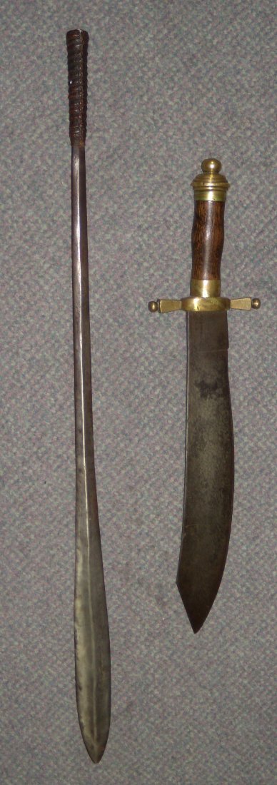 A machete, possibly American, and a sword, possibly: A machete, possibly American, and a sword, possibly north African, the wood handle to the former mounted with brass pommel and quillons. the single edged blade of scimitar shape, 51cm (20 in.) long, t