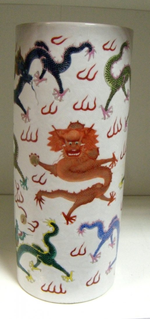A 19th century famille rose brush pot,: A 19th century famille rose brush pot, the tall cylindrical sides painted with lively dragons amongst flames chasing gilt pearls, the white ground incised with stylised clouds, six character mark of Y