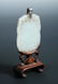 A jade pendant and stand