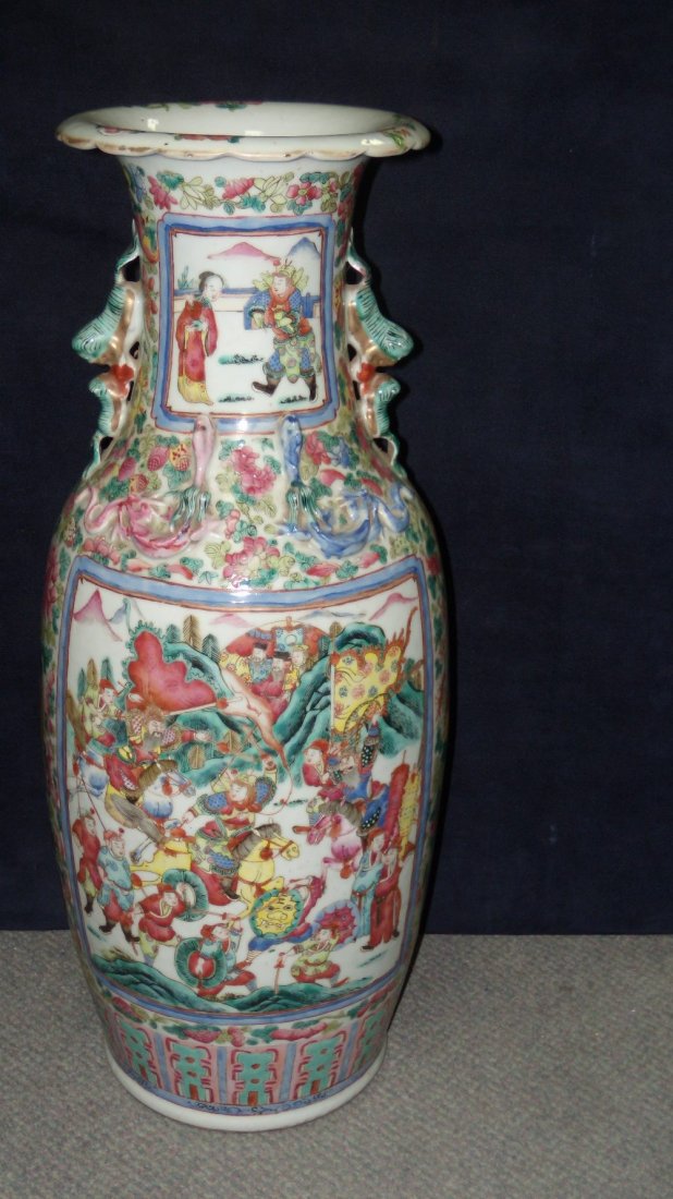 A 19th century Canton vase: A 19th century Canton vase painted with reserves of dignitaries and warriors on a floral ground, the shoulders applied with dragons below pairs of Buddhist lions forming the handles, 62cm (24.5 in) hi