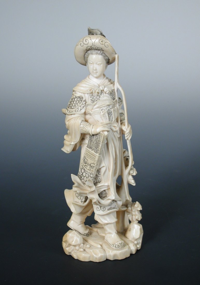 A late 19th/early 20th century ivory figure of a: A late 19th/early 20th century ivory figure of a youthful hunter standing with a bow in the left hand and the right resting on a quiver of arrows, the broad brimmed hat with plume of hair, 20cm (8 in)