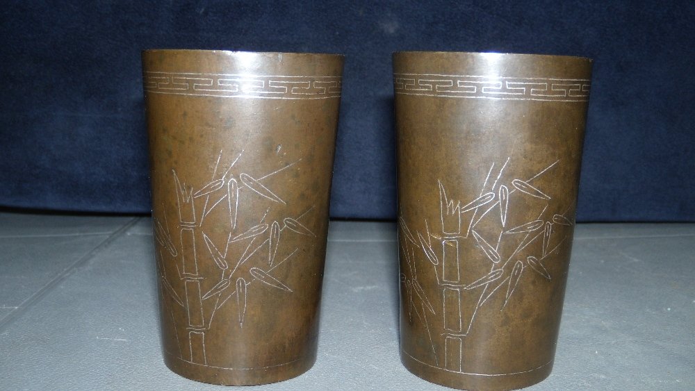Shi Sou, a pair of silver wire inlaid bronze beakers: Shi Sou, a pair of silver wire inlaid bronze beakers worked with bamboo on one side below the cloud scroll rim band and with an inscription on the other, the signature both in the inscription and on t