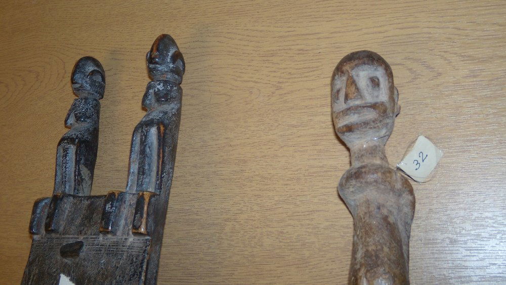 A Dogon latch and a figure, 1065 and 1052,: A Dogon latch and a figure, 1065 and 1052, two figures seated on top of the rectangular latch crossed centrally by a bar bolt, 35cm (13.75 in) high, the female figure, 29cm (11.5 in) high (2)