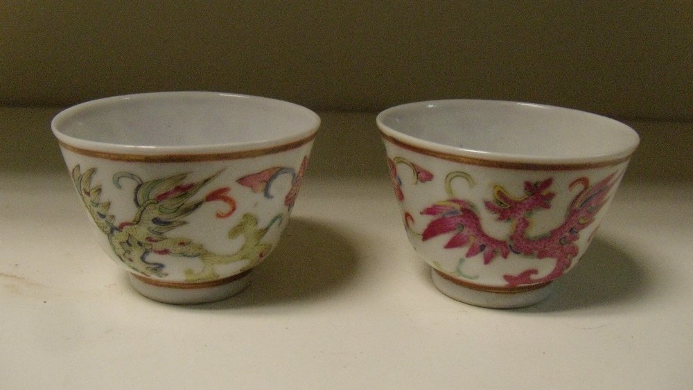 A pair of tea bowls, six character marks of Yongzheng,: A pair of tea bowls, six character marks of Yongzheng, the exteriors painted with alternating dragons and flowers between gilt lines, 6cm (2.25 in) diameter (2) (R)