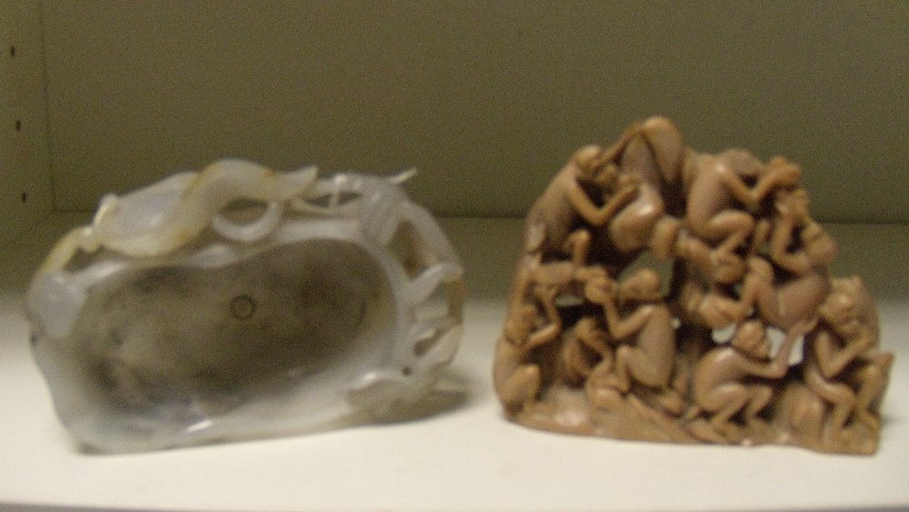 An agate brush washer and soapstone carving,: An agate brush washer and soapstone carving, the grey stone of the former carved as a lotus leaf, the head of a beast to one end amongst foliage, the base with one foot carved as a fly, 11cm (4.25 in)