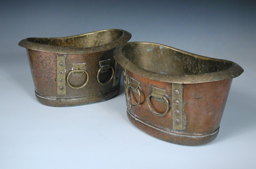 Wood & Co. for Liberty & Co., a pair of oval copper and: Wood & Co. for Liberty & Co., a pair of oval copper and brass mounted planters or wine coolers, circa 1900, each modelled as a Roman bath, the liners with rolled rims, rivet applied strap work and loo