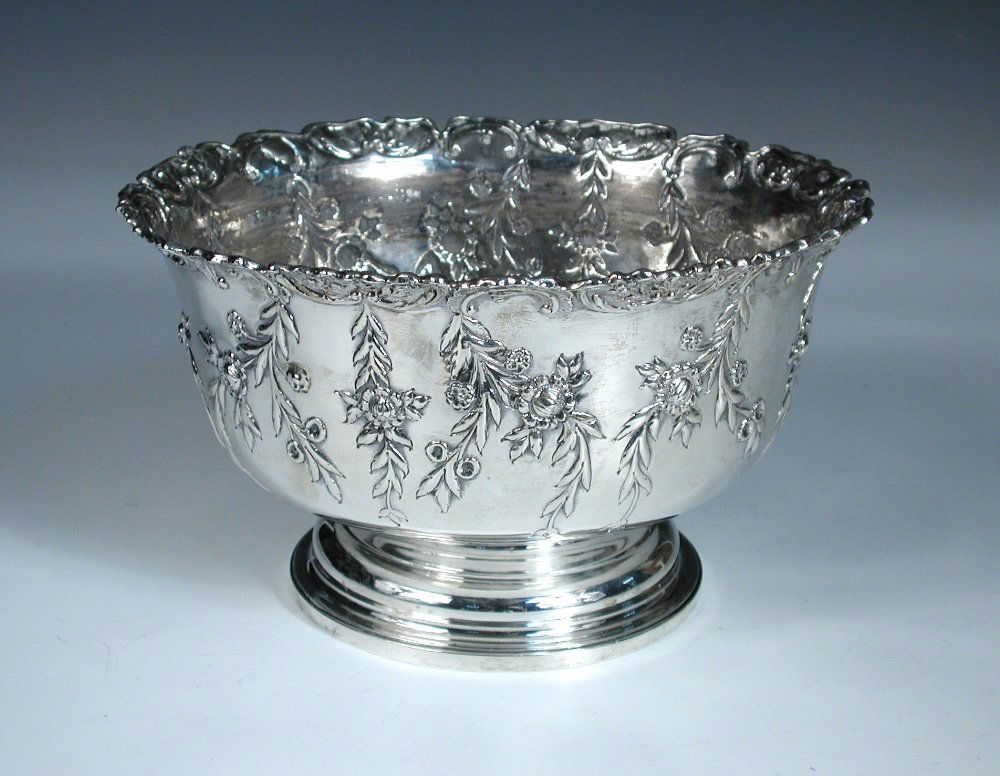 A Victorian silver rosebowl,: A Victorian silver rosebowl, by Charles Stuart Harris, London 1891, circular, embossed with sprigs of flowers below a shaped and scrolled edge, 23.5cm diameter, 19.96oz