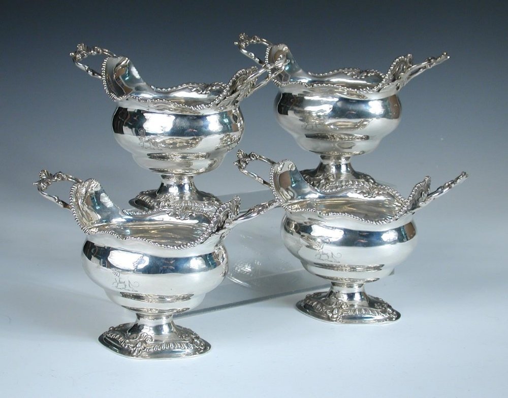 A set of four George III silver sauceboats,: A set of four George III silver sauceboats, by William Vincent, London 1772, each with an oval compressed bowl the shaped edges gadrooned and shell decorated, raised on a gadroon edged cast pedestal f
