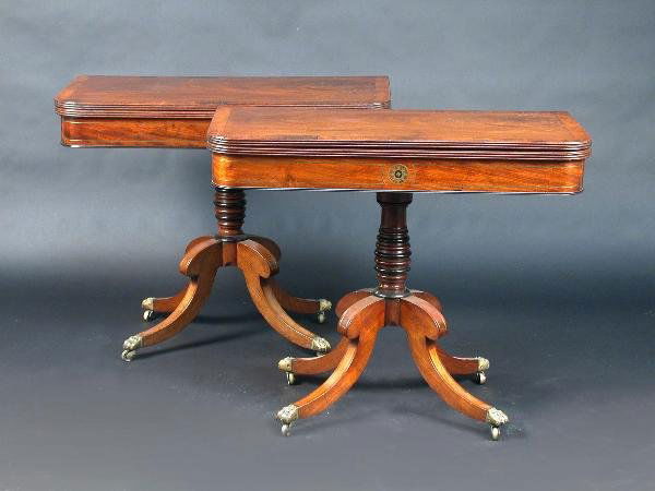 A pair of Regency mahogany tea tables: A pair of Regency mahogany tea tables each with rounded rectangular rosewood crossbanded fold over top above a brass inlaid frieze supported on a turned column standing on similarly inlaid splayed leg