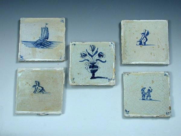 29 early 19th century Delft blue and white tiles: A collection of twenty-nine early 19th century Delft blue and white tiles to include: eleven painted with playful amorini five with flowers and five with dogs (29)