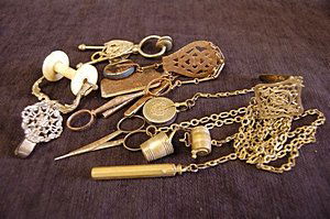 Three chatelaines and a skirt hem clamp, early-la: Three chatelaines and a skirt hem clamp, early-late 19th century, including cut steel example early 19th century, plated brass example late 19th century, the skirt hem clamp with silver mount, Birming