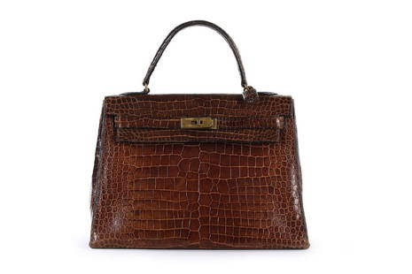 An Hermès brown crocodile Kelly bag, 1962, crocodylus: Description: An Hermès brown crocodile Kelly bag, 1962, crocodylus porosus, stamped in gold Hermès, Paris, with gilt hardware, leather covered padlock, with remains of fob and key, 32cm, 12 1/2in lo