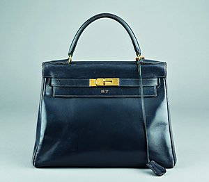 An Hermès navy leather Kelly bag, 1960s, one gilt br: An Hermès navy leather Kelly bag, 1960s, one gilt brass closure strap marked Hermès Paris, the leather also stamped in gold above the clasp, bearing SY" initials below clasp, with brass padlock