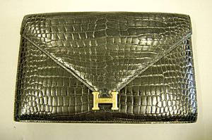 An Hermès black crocodile clutch/shoulder bag, Frenc: An Hermès black crocodile clutch/shoulder bag, French, 1980s, bearing maker's stamp to inner front closure, envelope shaped with gilt H clasp, detachable shoulder strap, 25.5cm, 10in long Please