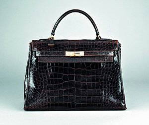 An Hermès chocolate brown crocodile leather Kelly ba: An Hermès chocolate brown crocodile leather Kelly bag, French 1970s, with maker's stamp to front closure, with croc covered lock, fob with key, 33cm, 13in long Please note there are export