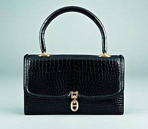 An Hermès black crocodile handbag, pre 1970, stamped: An Hermès black crocodile handbag, pre 1970, stamped in gold to the inside front pocket, Hermès, Paris, with gilt brass lifter clasp, curved handle, lined in soft black kid, 23cm, 9in long Please