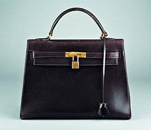 An Hermès chocolate brown leather Kelly bag, French: An Hermès chocolate brown leather Kelly bag, French, 1960s-70s, bearing maker's stamps to front closure, with brass lock, fob with key, 33cm, 13in. long