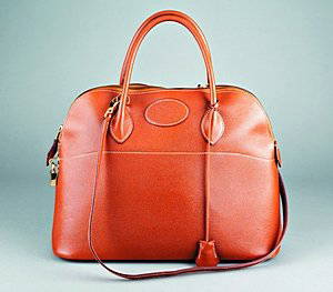 An Hermès 'Bolide' tan leather handbag, circa 1980,: An Hermès 'Bolide' tan leather handbag, circa 1980, with gilt brass padlock, two keys, fob, the shoulder strap and tan kid lining bearing maker's marks, 36cm, 14in