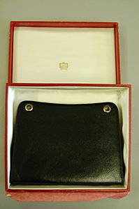 A Cartier Ltd, London black pin-wheel leather clutc: A Cartier Ltd, London black pin-wheel leather clutch/shoulder bag, 1960s, stamped in gold to the interior, with simple gilt metal lifter clasp, eyelets to the top edges and studs to the base, 25cm,