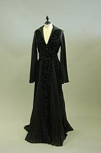 A Thea Porter black voided velvet gown, 1970s, lab: A Thea Porter black voided velvet gown, 1970s, labelled size 12, with pleated chiffon sleeves and inserts at skirt, approx. bust 92cm, 36in, waist 68cm, 27in