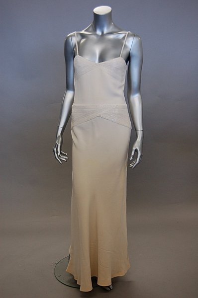 A Guy Laroche couture white crepe evening gown, 1: A Guy Laroche couture white crepe evening gown, 1976, labelled and numbered, with criss-cross bands of shimmering bugle beads to the bust and hips, bust 81cm, 32in Please note that VAT is payable on t