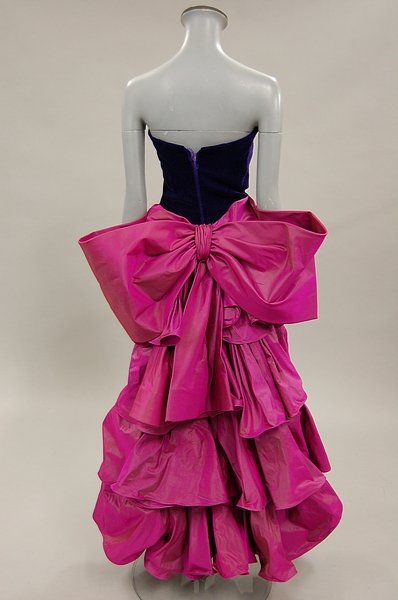 A Guy Laroche fuchsia pink and purple velvet cock: A Guy Laroche fuchsia pink and purple velvet cocktail dress, mid 1980s, Paris labelled, with boned strapless bodice, horizontally swathed pink taffeta skirt with floor-length flamenco style train, bus