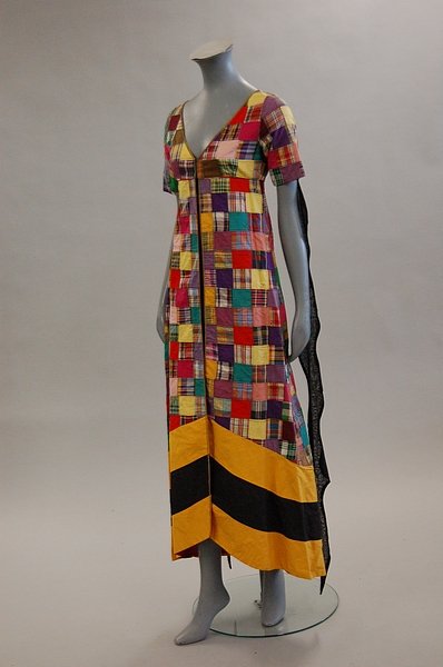 A Thea Porter patchworked tunic, early 1970s, cout: A Thea Porter patchworked tunic, early 1970s, couture labelled, composed of a patchwork of madras cottons, yellow and black striped hem, black gothic streamers to the sleeves, bust 81cm, 32in
